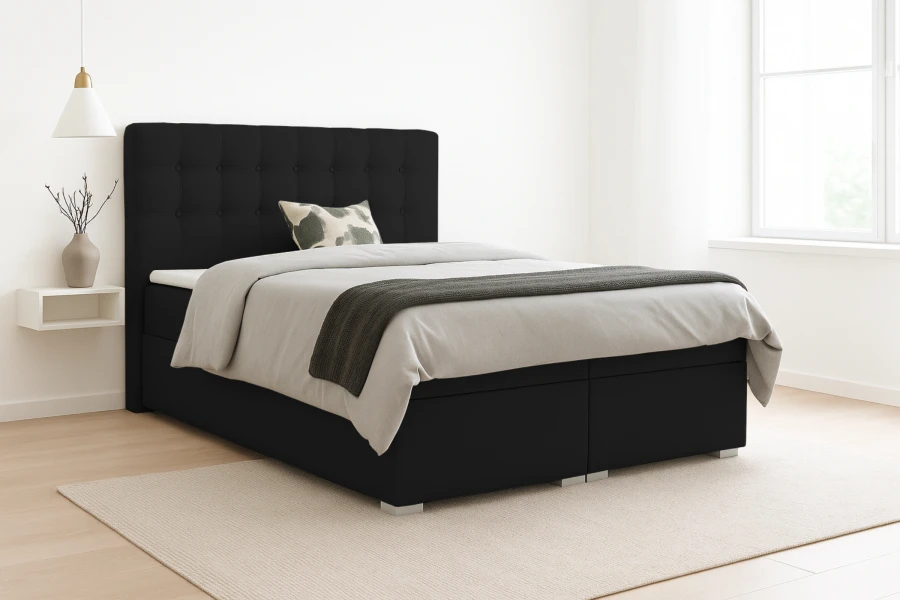 Modernes Boxspringbett in Schwarz mit gestepptem Kopfteil im hellen Schlafzimmer.