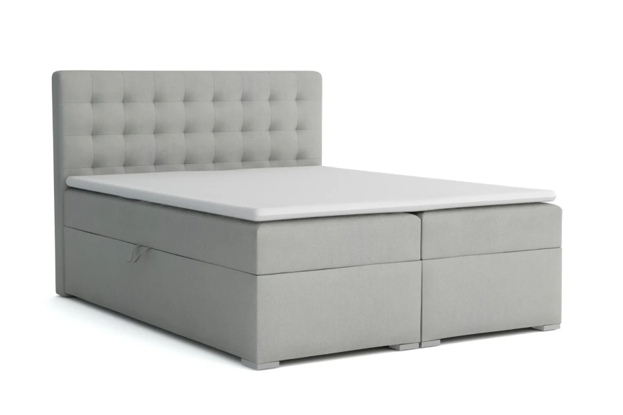 Graues Boxspringbett mit großem Bettkasten und gepolstertem Kopfteil, freigestellt.