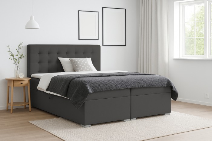 Modern donkergrijs boxspringbed met gecapitonneerd hoofdbord in een lichte slaapkamer.