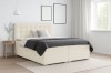 Modernes Boxspringbett in Beige in einem hellen, gemütlich eingerichteten Schlafzimmer.