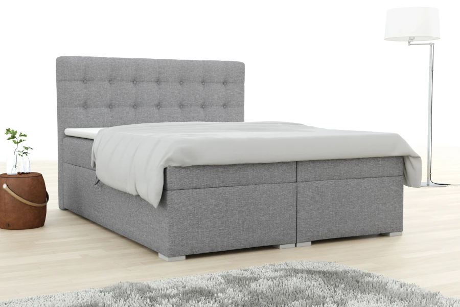 Modernes Boxspringbett Claudia in Grau mit gestepptem Kopfteil und gemütlichem Topper im Schlafzimmer.