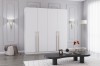 Moderner weißer Kleiderschrank mit goldenen Griffen in einem eleganten Interieur.