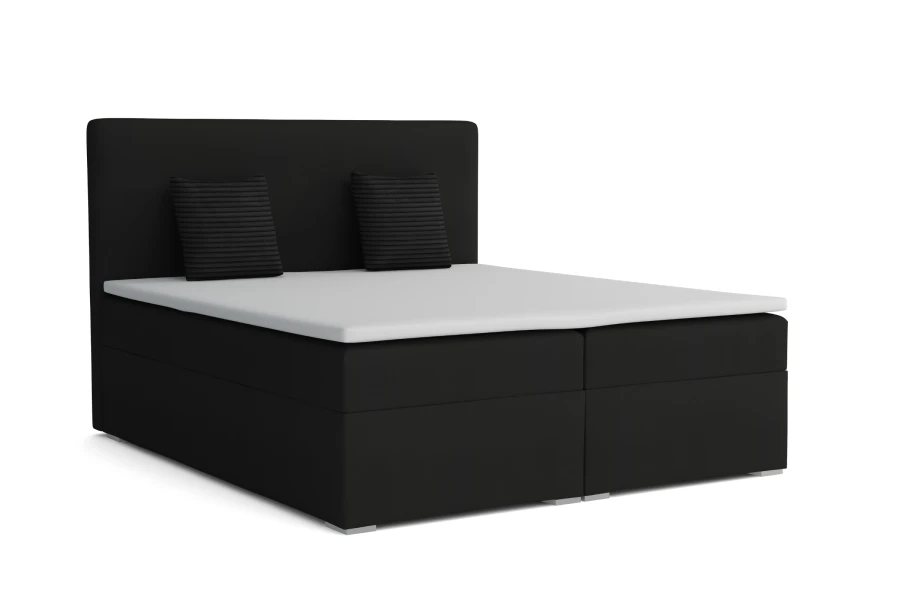 Schwarzes Boxspringbett mit weißem Topper und zwei Zierkissen vor weißem Hintergrund.