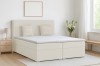 Modernes hellbeige Boxspringbett in einem hellen Schlafzimmer mit minimalistischer Einrichtung.