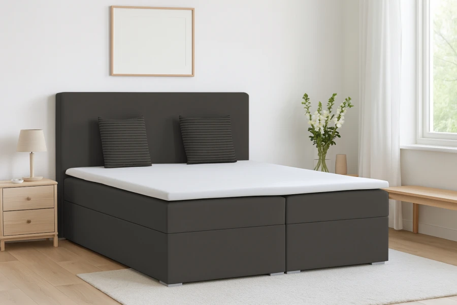 Dunkelgraues Boxspringbett in einem gemütlich und hell eingerichteten Schlafzimmer.
