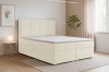 Helles Schlafzimmer mit modernem Boxspringbett in Beige und Dekoration.