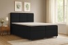 Modernes schwarzes Boxspringbett mit weißem Topper in gemütlichem Schlafzimmer.