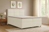 Helles beiges Boxspringbett im modernen Schlafzimmer-Ambiente mit Dekoration.