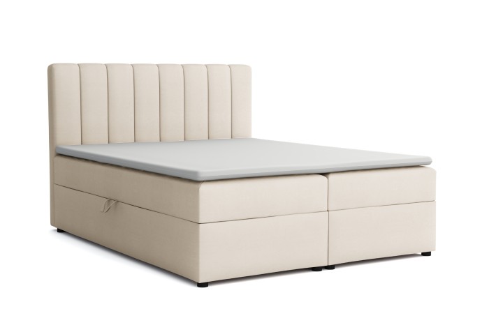 Beiges Boxspringbett mit hohem gepolstertem Kopfteil vor weißem Hintergrund.