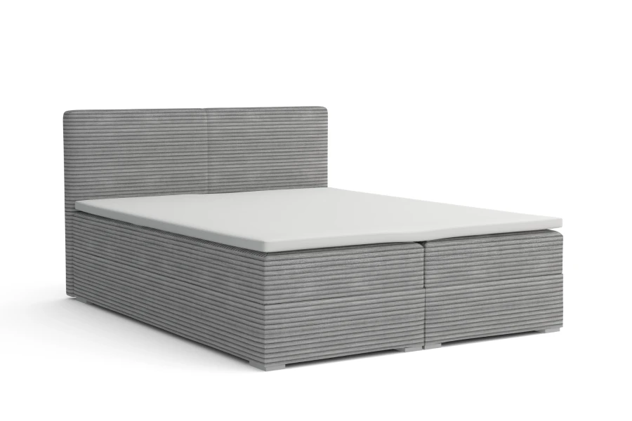 Graues Boxspringbett mit strukturiertem Cordbezug vor weißem Hintergrund.