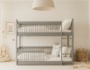 Frontansicht eines grauen Kinder-Etagenbetts aus Massivholz in einem hellen Kinderzimmer.