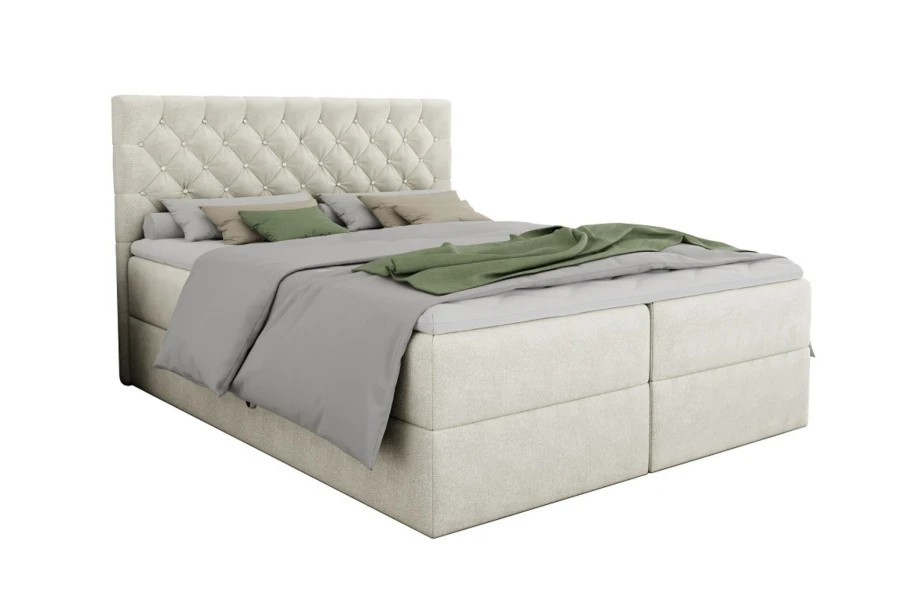 Cremefarbenes Boxspringbett mit Knopfheftung und Glitzersteinen auf weißem Grund.