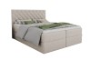 Elegantes beiges Boxspringbett mit Knopfheftung am Kopfteil und grauer Bettwäsche.