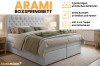 Boxspringbett Arami in grauem Design mit gestepptem Kopfteil und dekorativen Kissen.