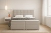 Frontansicht des beigen Boxspringbetts Abi mit hohem gestepptem Kopfteil und minimalistischer Deko.