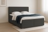 Dunkelgraues Boxspringbett Anthrazit mit weißer Bettwäsche und minimalistischer Deko.
