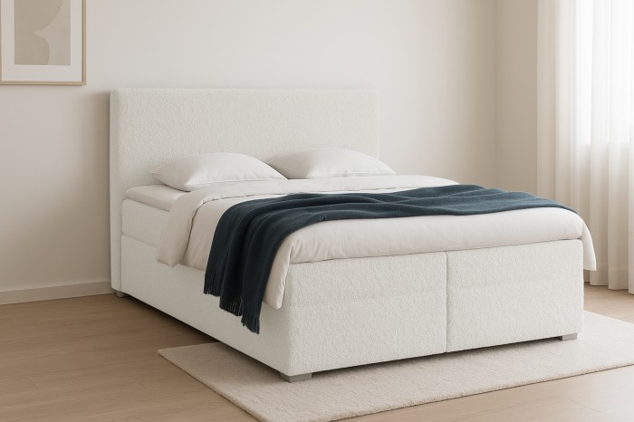 Witte bouclé boxspring met blauwe plaid in lichte, moderne slaapkamer.