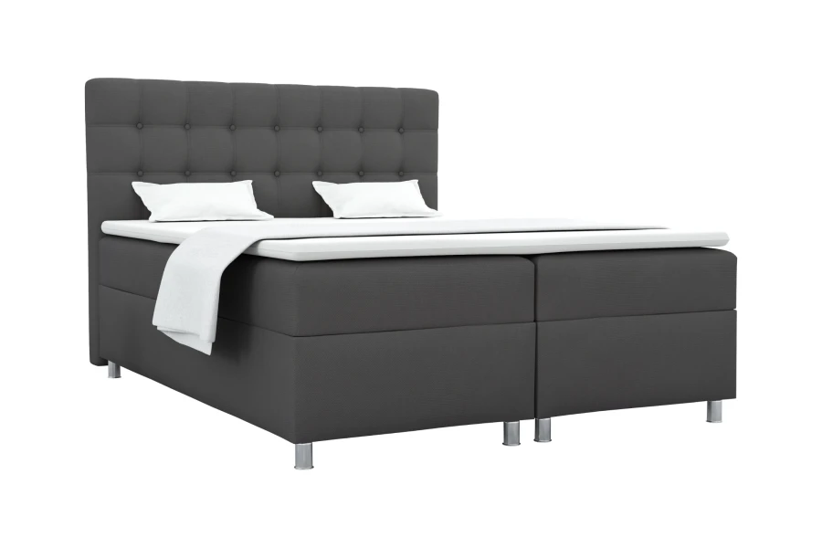 Dunkelgraues Boxspringbett mit gestepptem Kopfteil und Metallfüßen auf weißem Grund.
