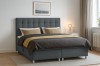 Stilvoll eingerichtetes Schlafzimmer mit einem modernen Boxspringbett in Grau.