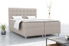 Beiges Brill Boxspringbett in einer modernen Raumsituation mit minimalistischer Dekoration.