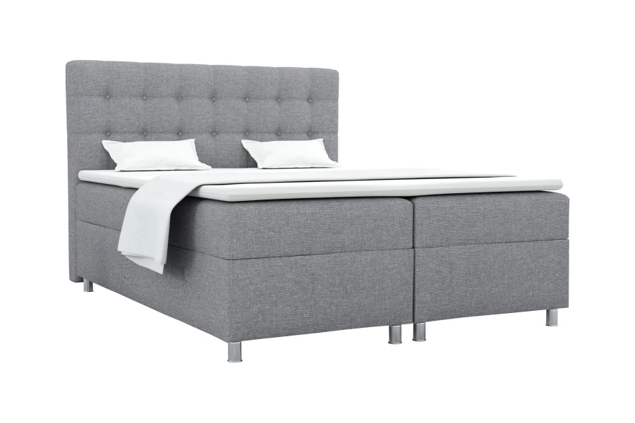 Modernes Boxspringbett in Grau mit gestepptem Kopfteil und weißer Matratzenauflage.