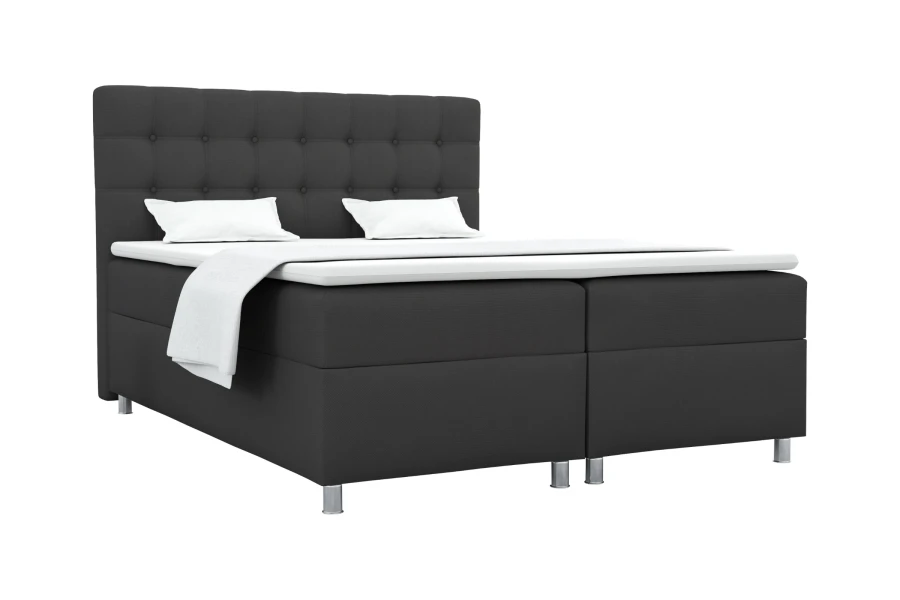 Anthrazitfarbenes Boxspringbett mit gestepptem Kopfteil und weißer Bettwäsche.
