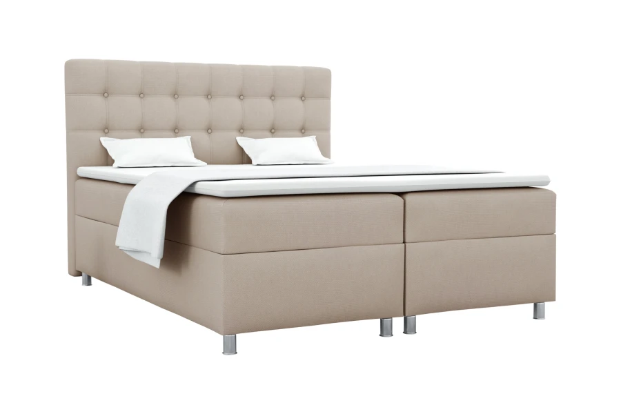 Beiges Boxspringbett mit gestepptem Kopfteil isoliert auf weißem Hintergrund.