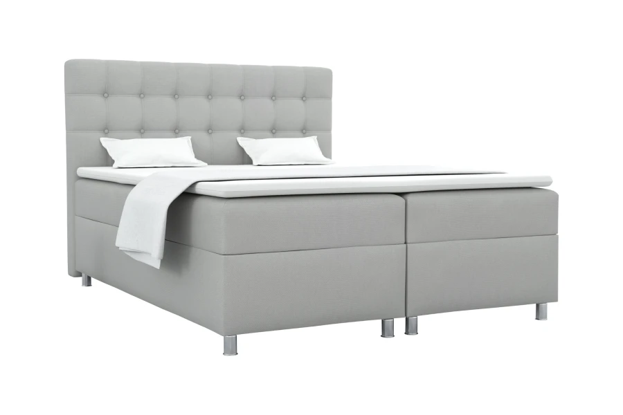Graues Boxspringbett mit modernem Steppkopfteil freigestellt vor weißem Hintergrund.
