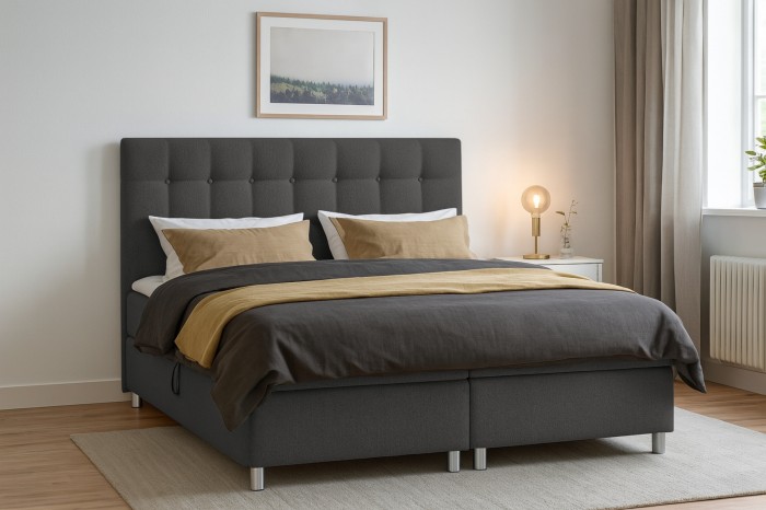 Modernes Boxspringbett in Anthrazit mit gestepptem Kopfteil im Schlafzimmer.