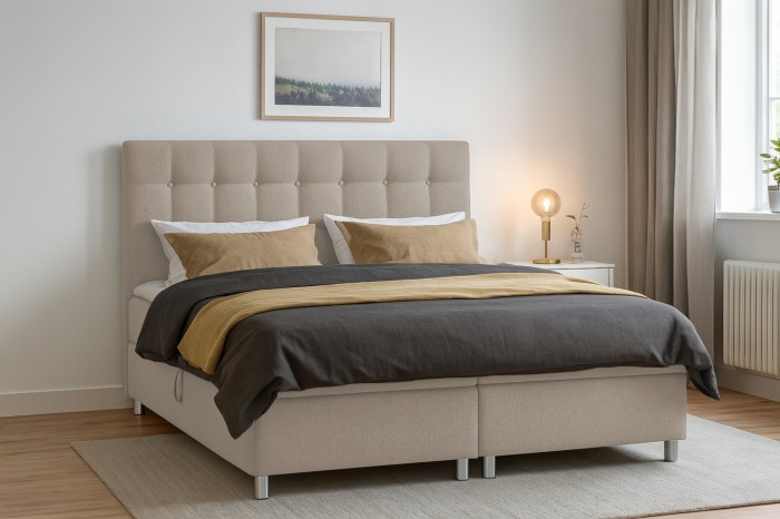 Boxspringbett in Beige im Schlafzimmer-Ambiente mit passender Bettwäsche und Deko.