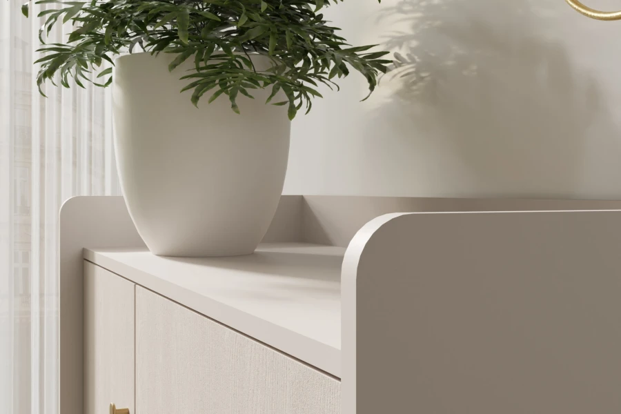 Oberseite einer beige Kommode mit abgerundeten Seitenwänden und einer grünen Zimmerpflanze.
