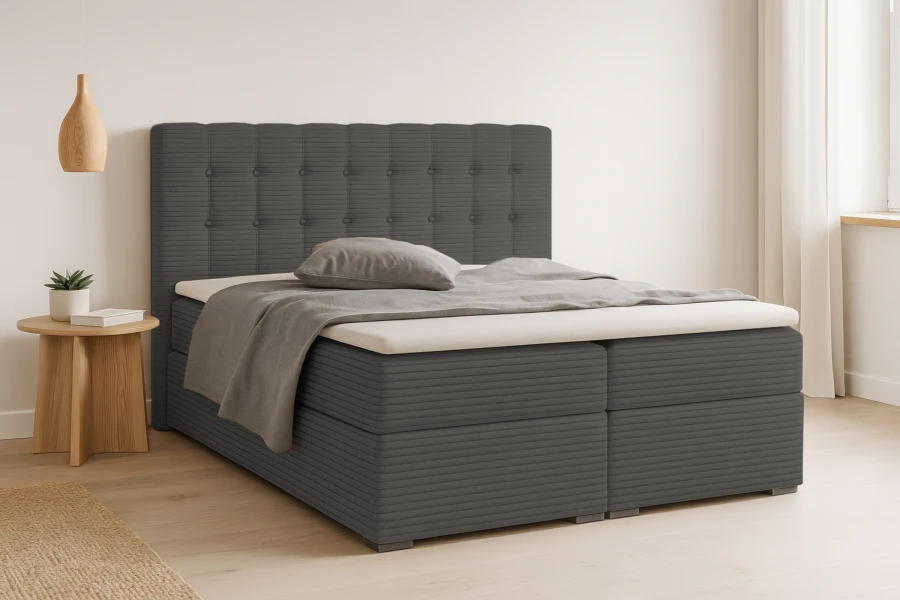Modernes dunkelgraues Boxspringbett mit Steppmuster am Kopfteil im hellen Schlafzimmer.