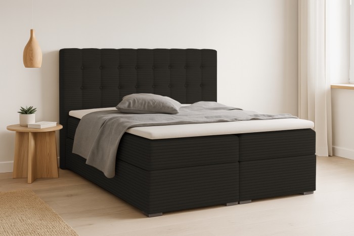 Modernes Boxspringbett in dunklem Cord-Stoff mit gepolstertem Kopfteil im hellen Schlafzimmer.