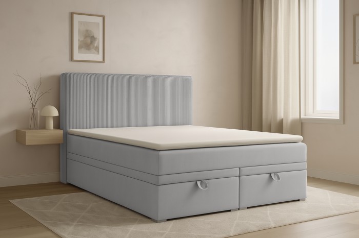Modernes graues Daga Boxspringbett in einem hellen, gemütlich eingerichteten Schlafzimmer.