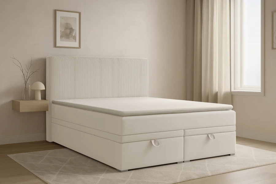 Gemütliches Schlafzimmer-Ambiente mit einem hellen Boxspringbett auf einem grauen Teppich.
