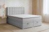Modernes hellgraues Boxspringbett mit hohem Kopfteil und praktischem Stauraum durch zwei Bettkästen.