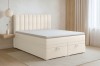 Stilvolles Schlafzimmer-Ambiente mit beigem Boxspringbett, hellem Teppich und dezenter Dekoration.