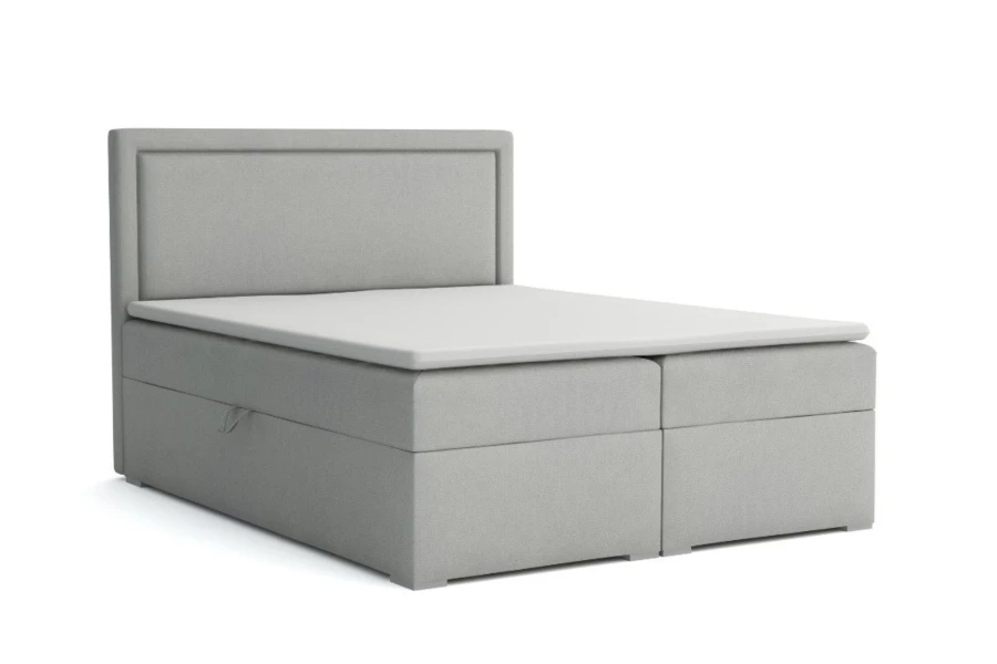 Freigestelltes hellgraues Boxspringbett mit hohem Kopfteil und weißem Topper.