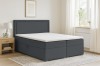 Modernes Boxspringbett in Dunkelgrau im hell eingerichteten Schlafzimmer.