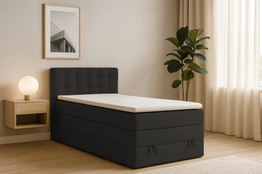 Gemütliches Schlafzimmer mit modernem schwarzen Boxspringbett, Nachttisch und Zimmerpflanze.