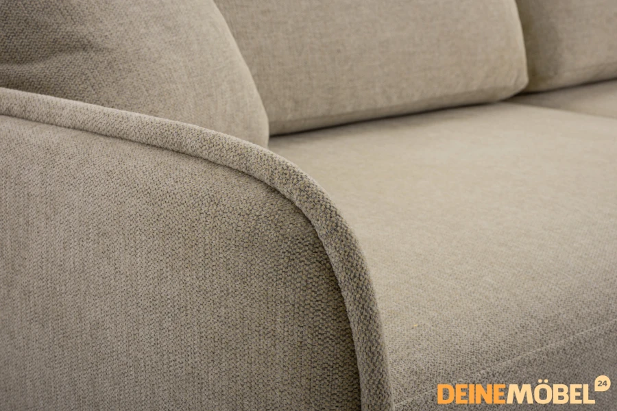 Detailansicht der Armlehne und des beigen Webstoffs eines modernen Sofas.