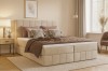 Gemütliches beige Boxspringbett in modernem Schlafzimmer mit brauner Tagesdecke und Kissen.