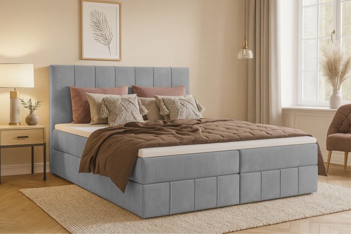 Hellgraues Boho Boxspringbett mit vertikaler Steppung in wohnlichem Ambiente.