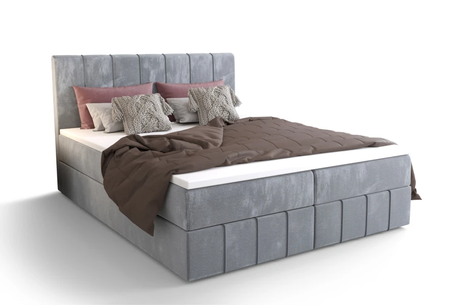 Hellgraues Boho Boxspringbett vor weißem Hintergrund – Ansicht von vorne links.