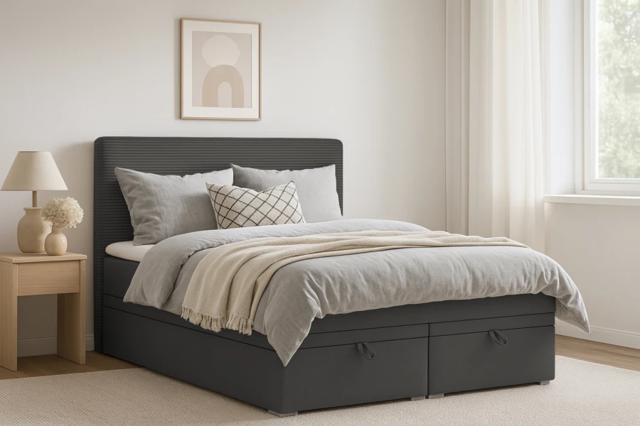Anthrazitfarbenes Boxspringbett mit Stauraum-Schubladen in einem hellen Schlafzimmer.