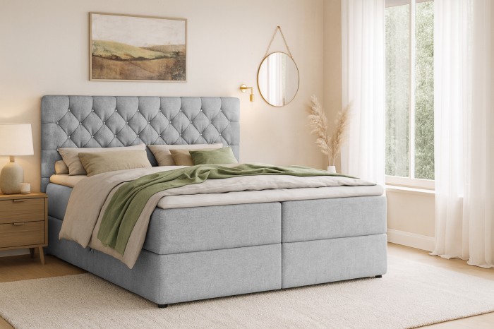 Gezellige slaapkamer met lichtgrijs boxspringbed, nachtkastje en moderne wanddecoratie.