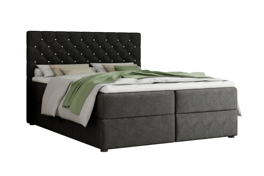Modern zwart boxspringbed met gestoffeerd hoofdbord en groene sprei.