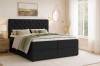 Ingerichte slaapkamer met antracietkleurig boxspringbed, licht tapijt en decoratie.