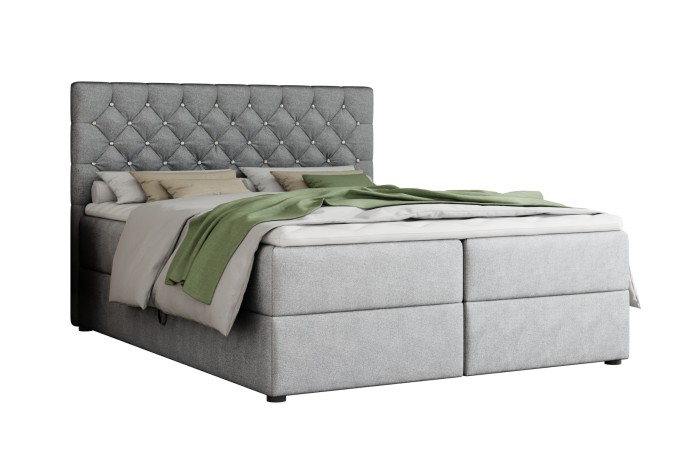 Modern boxspringbed in lichtgrijs met gecapitonneerd hoofdbord tegen een witte achtergrond.
