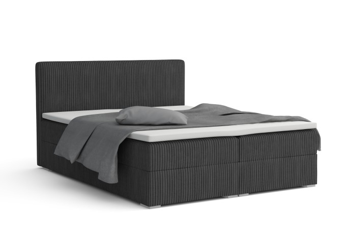 Modern grijs boxspringbed met cord-bekleding en beddengoed voor een witte achtergrond.